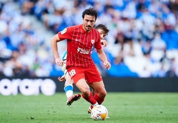 Cristian Portugues of Real Sociedad duels for the ball with Thomas Delaney of Sevilla FC during the La Liga Santander match between Real Sociedad and...