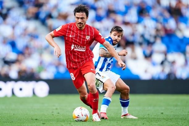 Cristian Portugues of Real Sociedad duels for the ball with Thomas Delaney of Sevilla FC during the La Liga Santander match between Real Sociedad and...