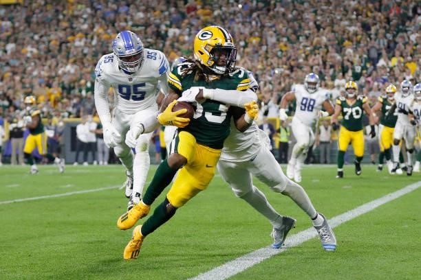Aaron Jones of the Green Bay Packers runs for a touchdown against Tracy Walker III of the Detroit Lions during the first half at Lambeau Field on...