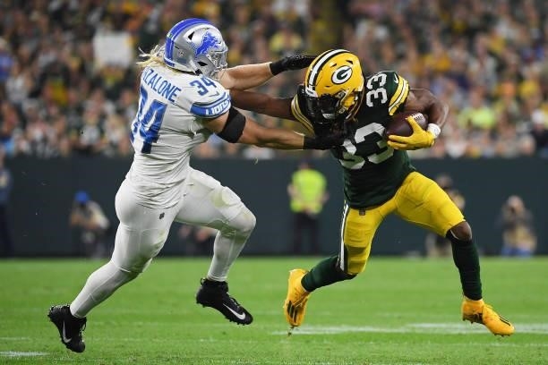 Aaron Jones of the Green Bay Packers shakes free from the hands of Alex Anzalone of the Detroit Lions during the first half at Lambeau Field on...