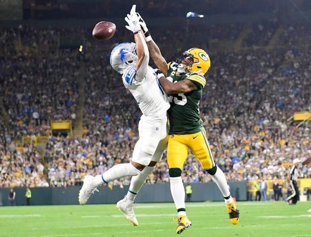 Jaire Alexander of the Green Bay Packers breaks-up a pass against Amon-Ra St. Brown of the Detroit Lions during the first half at Lambeau Field on...