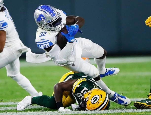 Andre Swift of the Detroit Lions is tackled by Darnell Savage of the Green Bay Packers during the first half at Lambeau Field on September 20, 2021...
