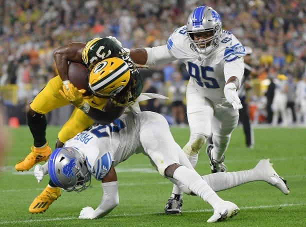 Aaron Jones of the Green Bay Packers is tackled by Bobby Price of the Detroit Lions during the second half at Lambeau Field on September 20, 2021 in...