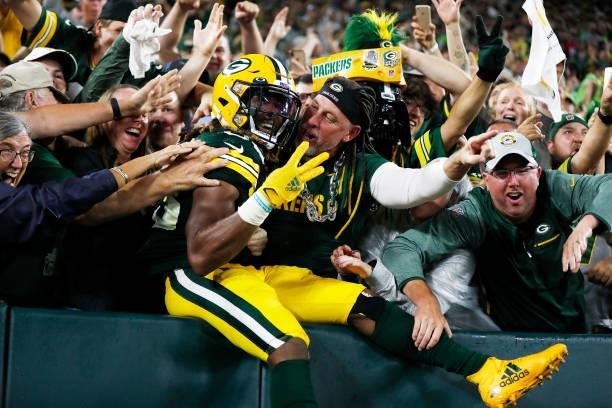 Aaron Jones of the Green Bay Packers does the Lambeau Leap to celebrate his third touchdown of the night against the Detroit Lions during the second...