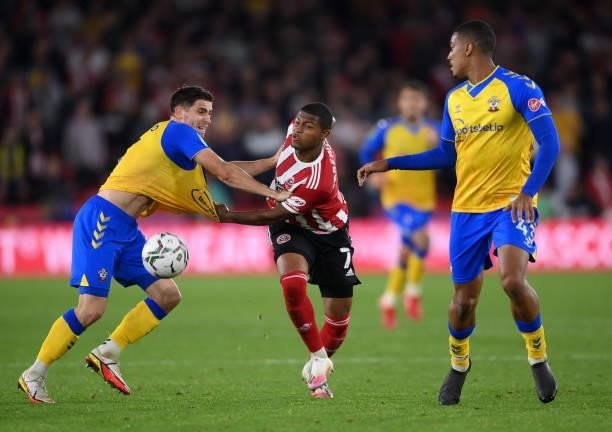 Romain Perraud of Southampton is challenged by Rhian Brewster of Sheffield United watched by Yan Valery of Southampton during the Carabao Cup Third...
