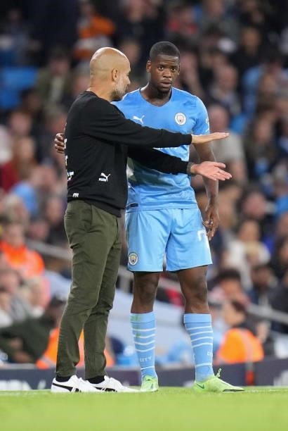 Pep Guardiola, Manager of Manchester City interacts with Luke Mbete of Manchester City during the Carabao Cup Third Round match between Manchester...