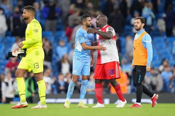 Riyad Mahrez of Manchester City interacts with Adebayo Akinfenwa of Wycombe Wanderers after the Carabao Cup Third Round match between Manchester City...