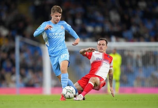 James McAtee of Manchester City is tackled by Josh Scowen of Wycombe Wanderers during the Carabao Cup Third Round match between Manchester City and...