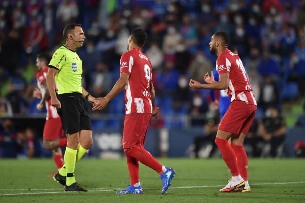 Referee Cuadra Fernandez has a word with Luis Suarez and Cunha of Atletico de Madrid during the La Liga Santander match between Getafe CF and Club...
