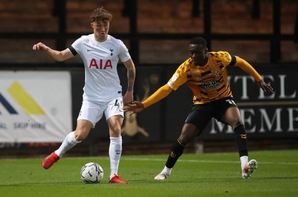 Alfie Devine of Tottenham Hotspur U21 looks to play the ball watched by Jubril Okedina of Cambridge United during the Papa John's Trophy match...