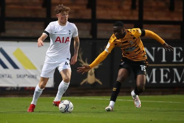 Alfie Devine of Tottenham Hotspur U21 looks to play the ball watched by Jubril Okedina of Cambridge United during the Papa John's Trophy match...