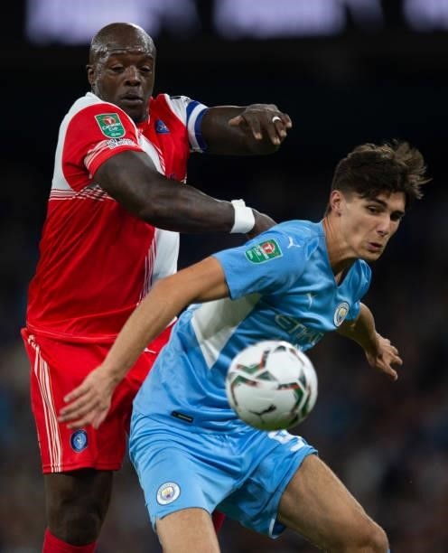 Finley Burns of Manchester City and Adebayo Akinfenwa of Wycombe Wanderers in action during the Carabao Cup Third Round match between Manchester City...