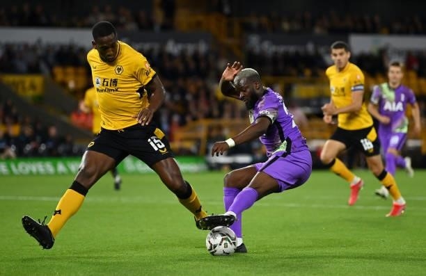 Tanguy Ndombele of Tottenham Hotspur battles for possession with Willy Boly of Wolverhampton Wanderers before scoring his sides first goal during the...
