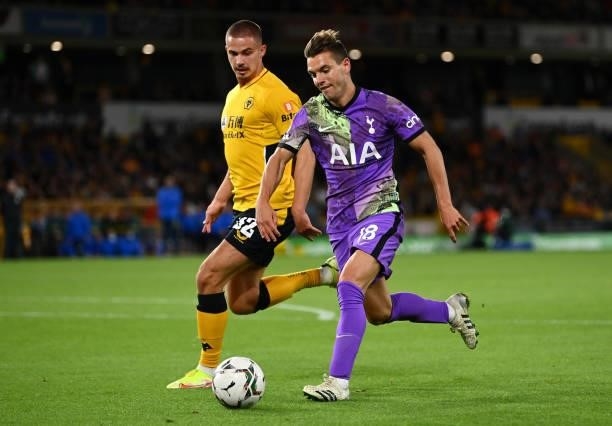 Giovani Lo Celso of Tottenham Hotspur runs with the ball whilst under pressure from Leander Dendoncker of Wolverhampton Wanderers during the Carabao...