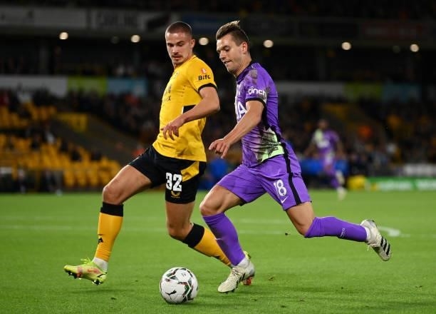 Giovani Lo Celso of Tottenham Hotspur runs with the ball whilst under pressure from Leander Dendoncker of Wolverhampton Wanderers during the Carabao...