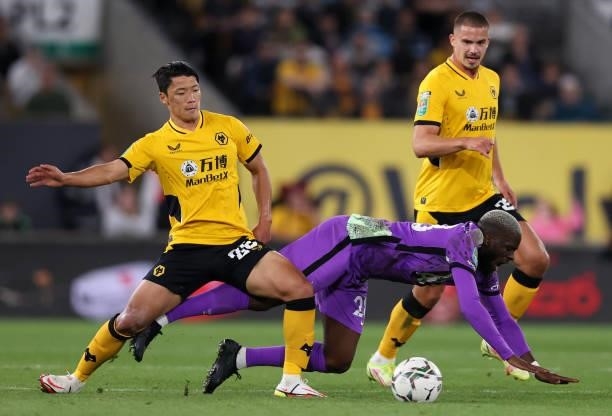 Tanguy Ndombele of Tottenham Hotspur is challenged by Hee Chan Hwang of Wolverhampton Wanderers during the Carabao Cup Third Round match between...