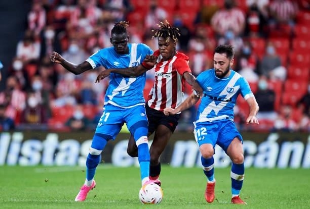 Nico Williams Jr of Athletic Bilbao battles for possession with Pathe Ciss and Unai Lopez of Rayo Vallecano during the La Liga Santander match...