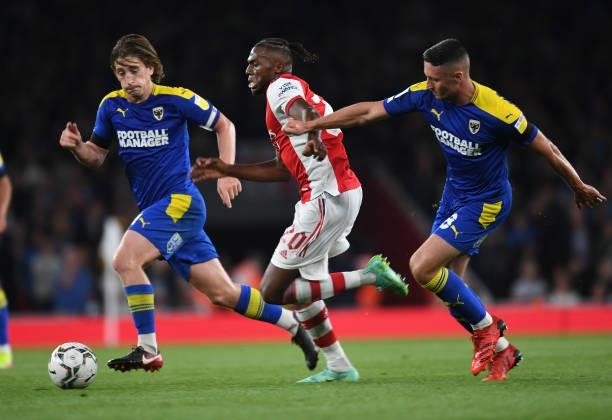 Nuno Tavares of Arsenal takes on Alex Woodyard and Anthony Hartigan of Wimbledon during the Carabao Cup Third Round match between Arsenal and AFC...