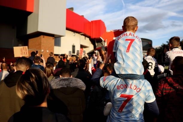 Fans wearing Cristiano Ronaldo shirts await the arrival of the team bus during the Carabao Cup Third Round match between Manchester United and West...
