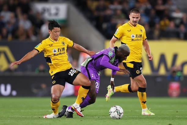 Tanguy Ndombele of Tottenham Hotspur is challenged by Hee-chan Hwang of Wolverhampton Wanderers during the Carabao Cup Third Round match between...