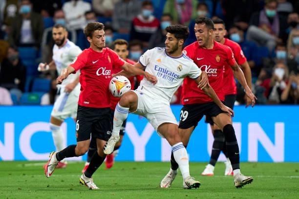 Marco Asensio of Real Madrid CF battle for the ball with Aleix Febas of RDC Mallorca during the La Liga Santander match between Real Madrid CF and...
