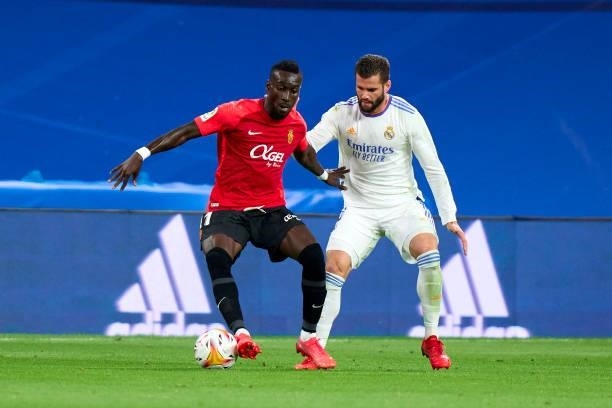 Nacho Fernandez of Real Madrid CF battle for the ball with Lago Junior of RDC Mallorca during the La Liga Santander match between Real Madrid CF and...