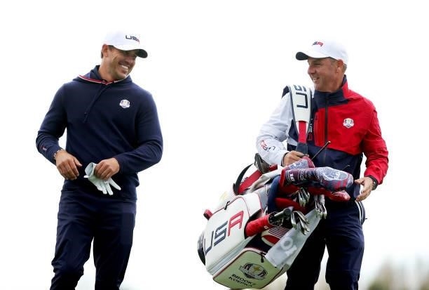 Brooks Koepka of team United States and his caddie Ricky Elliott look on from the sixth tee during practice rounds prior to the 43rd Ryder Cup at...