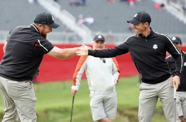 Shane Lowry of Ireland and team Europe and Rory McIlroy of Northern Ireland and team Europe celebrate on the ninth green during practice rounds prior...