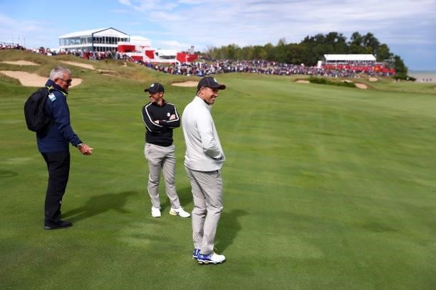 Rory McIlroy of Northern Ireland and team Europe and Captain Padraig Harrington of Ireland and team Europe look on from the eighth fairway during...