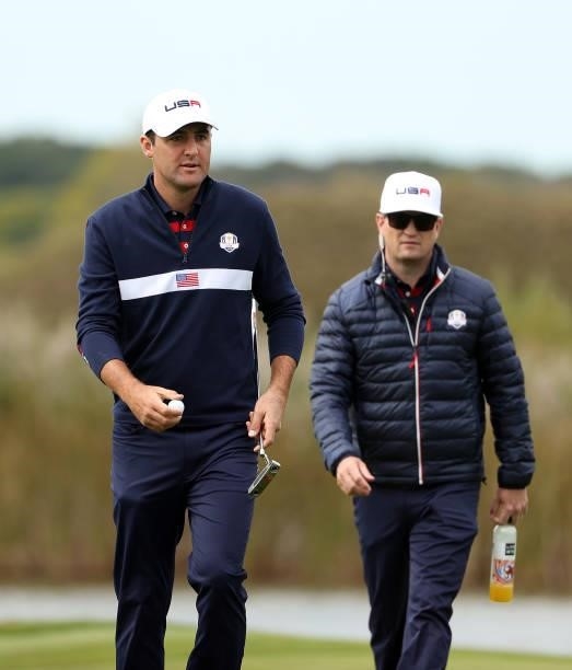 Scottie Scheffler of team United States and vice-captain Zach Johnson of team United States walk across the course during practice rounds prior to...