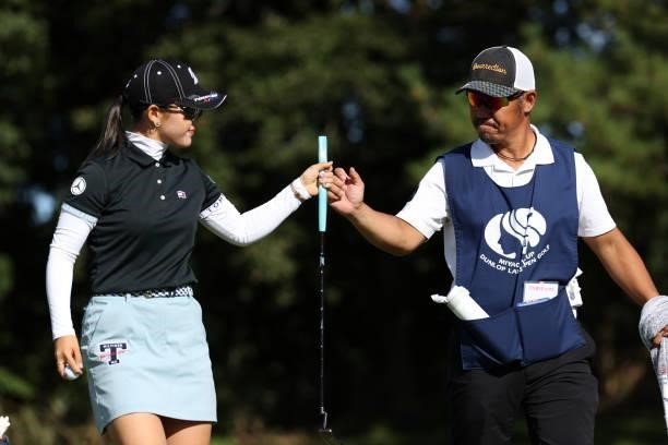 Yuri Yoshida of Japan fist bumps with her caddie after the birdie on the 14th green during the first round of the Miyagi TV Cup Dunlop Ladies Open at...