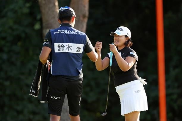 Ai Suzuki of Japan fist bumps with her caddie after the birdie on the 16th green during the first round of the Miyagi TV Cup Dunlop Ladies Open at...