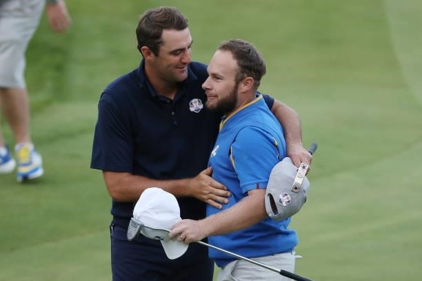 Scottie Scheffler of team United States and Tyrrell Hatton of England and team Europe embrace on the 18th green after their match during Friday...