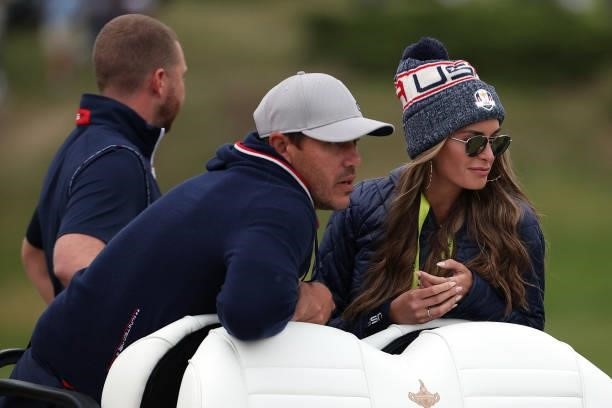 Brooks Koepka of team United States and wife Jena Sims ride on a cart during Friday Afternoon Fourball Matches of the 43rd Ryder Cup at Whistling...