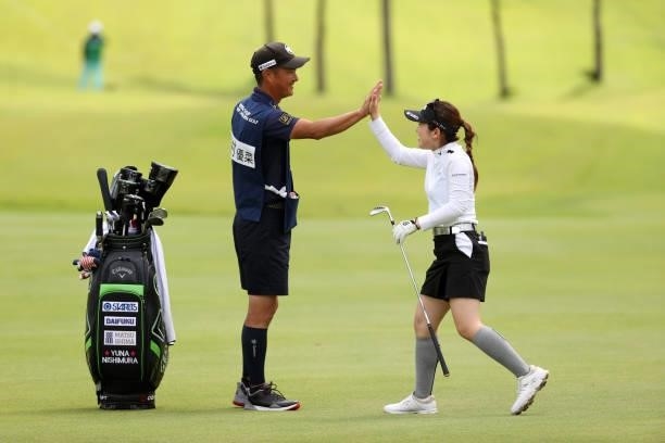 Yuna Nishimura of Japan high fives with her caddie after a chip-in-eagle on the 8th hole during the second round of the Miyagi TV Cup Dunlop Ladies...