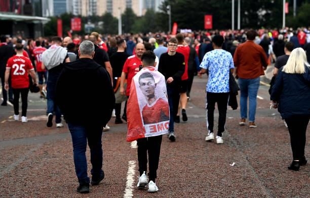 Manchester United fans make their way to the stadium prior to the Premier League match between Manchester United and Aston Villa at Old Trafford on...