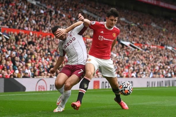 Harry Maguire of Manchester United battles for possession with John McGinn of Aston Villa during the Premier League match between Manchester United...