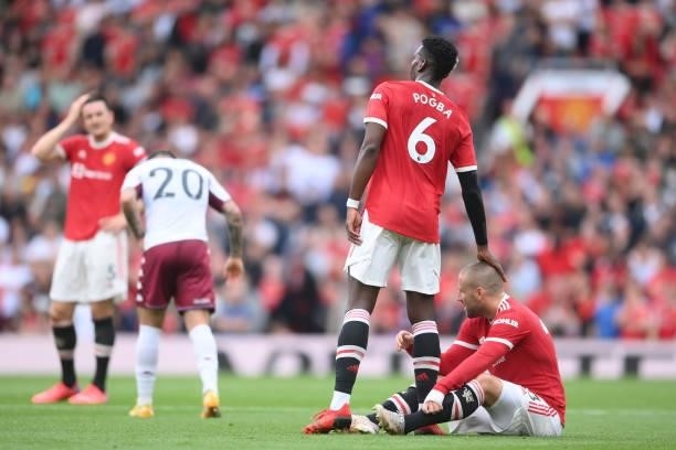 Paul Pogba of Manchester United with an injured Luke Shaw during the Premier League match between Manchester United and Aston Villa at Old Trafford...