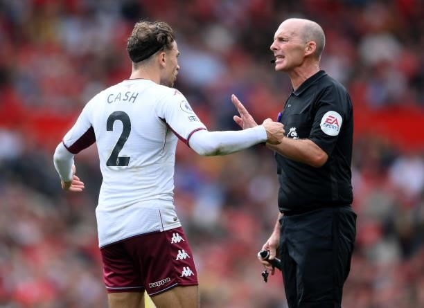 Referee Mike Dean with Matty Cash of Aston Villa during the Premier League match between Manchester United and Aston Villa at Old Trafford on...