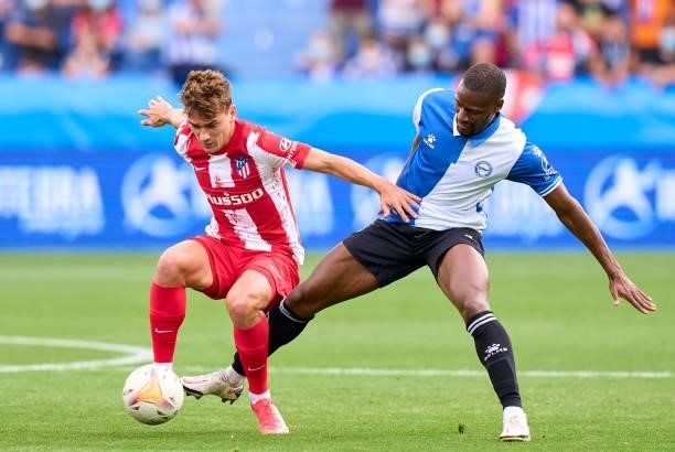 Mamadou Ndiaye of Deportivo Alaves competes for the ball with Antoine Griezmann of Club Atletico de Madrid during the La Liga Santander match between...