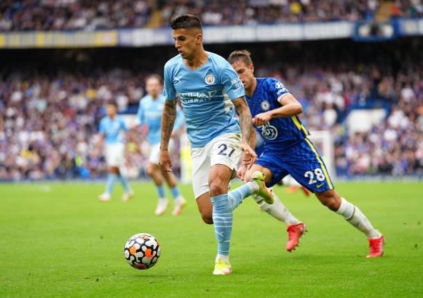 Joao Cancelo of Manchester City runs with the ball whilst under pressure from Cesar Azpilicueta of Chelsea during the Premier League match between...