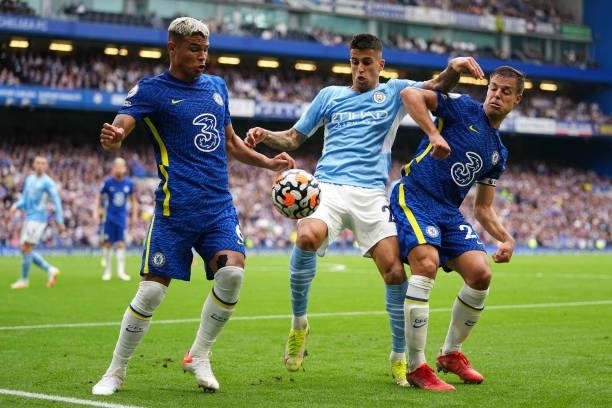 Joao Cancelo of Manchester City battles for the ball with Thiago Silva and Cesar Azpilicueta of Chelsea during the Premier League match between...