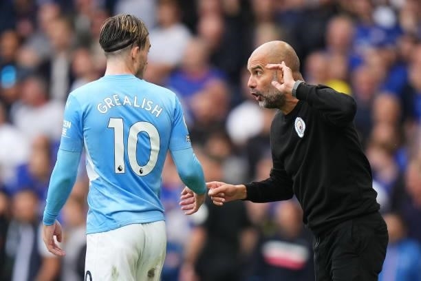 Pep Guardiola, Manager of Manchester City interacts with Jack Grealish of Manchester City during the Premier League match between Chelsea and...