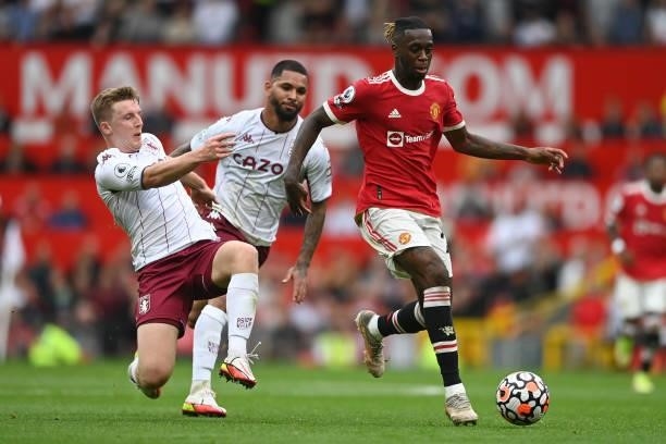 Aaron Wan-Bissaka of Manchester United is tackled by Matt Target of Aston Villa during the Premier League match between Manchester United and Aston...