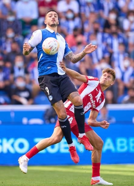 Mato Joselu of Deportivo Alaves competes for the ball with Marcos Llorente of Club Atletico de Madrid during the La Liga Santander match between...