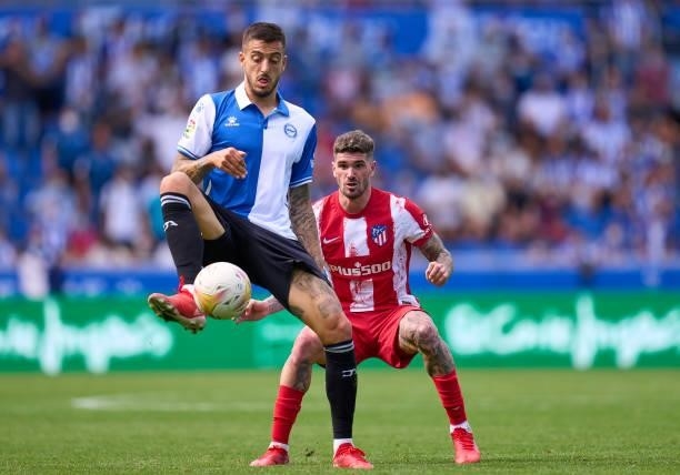 Mato Joselu of Deportivo Alaves competes for the ball with Rodrigo Javier de Paul of Club Atletico de Madrid during the La Liga Santander match...