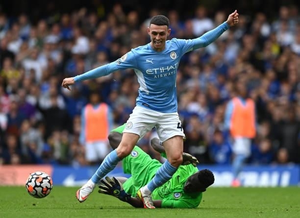 Phil Foden of Manchester City is tackled by Edouard Mendy of Chelsea during the Premier League match between Chelsea and Manchester City at Stamford...