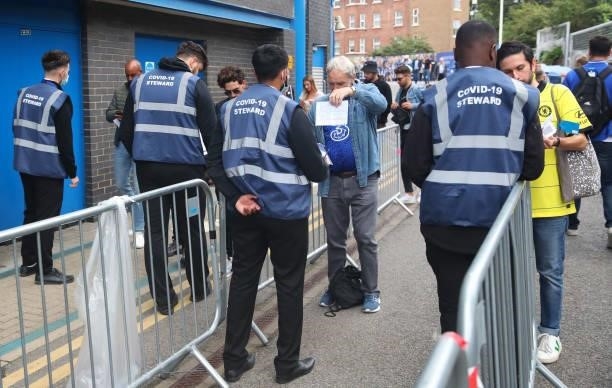 Stewards check the covid status of fans as they arrive ahead of the Premier League match between Chelsea and Manchester City at Stamford Bridge on...