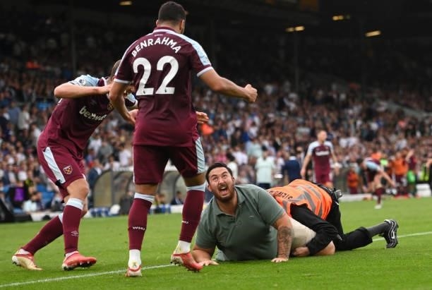 Pitch invader is seen celebrating their side's second goal with Tomas Soucek and Said Benrahma scored by Michail Antonio of West Ham United during...