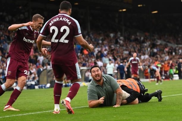 Pitch invader is seen celebrating their side's second goal with Tomas Soucek and Said Benrahma scored by Michail Antonio of West Ham United during...